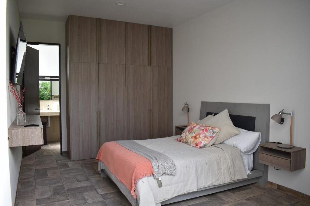 a bedroom with a bed with a wooden cabinet at Loft Montenegro in Aguascalientes