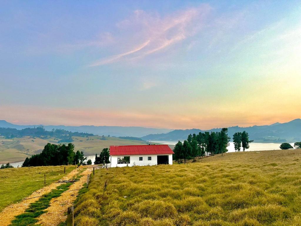 une maison blanche au milieu d'un champ dans l'établissement Finca Siberia, Sisga, à Tilatá