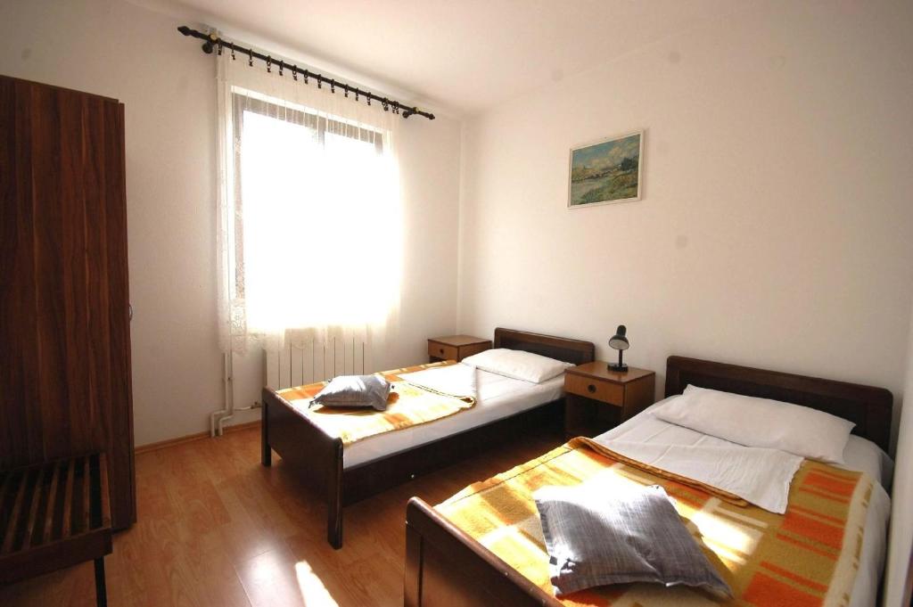 2 camas en una habitación con ventana en Ferienwohnung für 7 Personen ca 110 qm in Njivice, Kvarner Bucht Krk, en Njivice