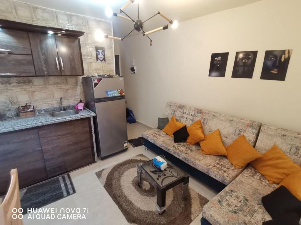 Tavira Resort في رأس سدر: غرفة معيشة مع أريكة ومطبخ