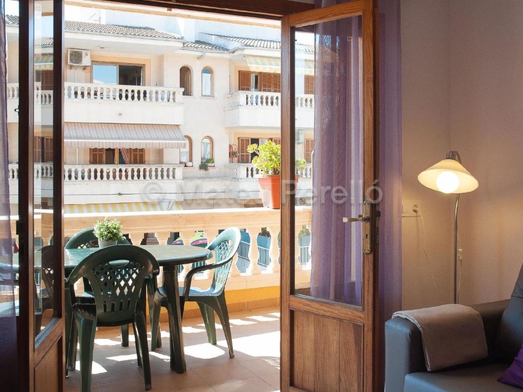 a dining room with a table and chairs and a balcony at Ferienwohnung in Son Baulo mit Grill in Can Picafort