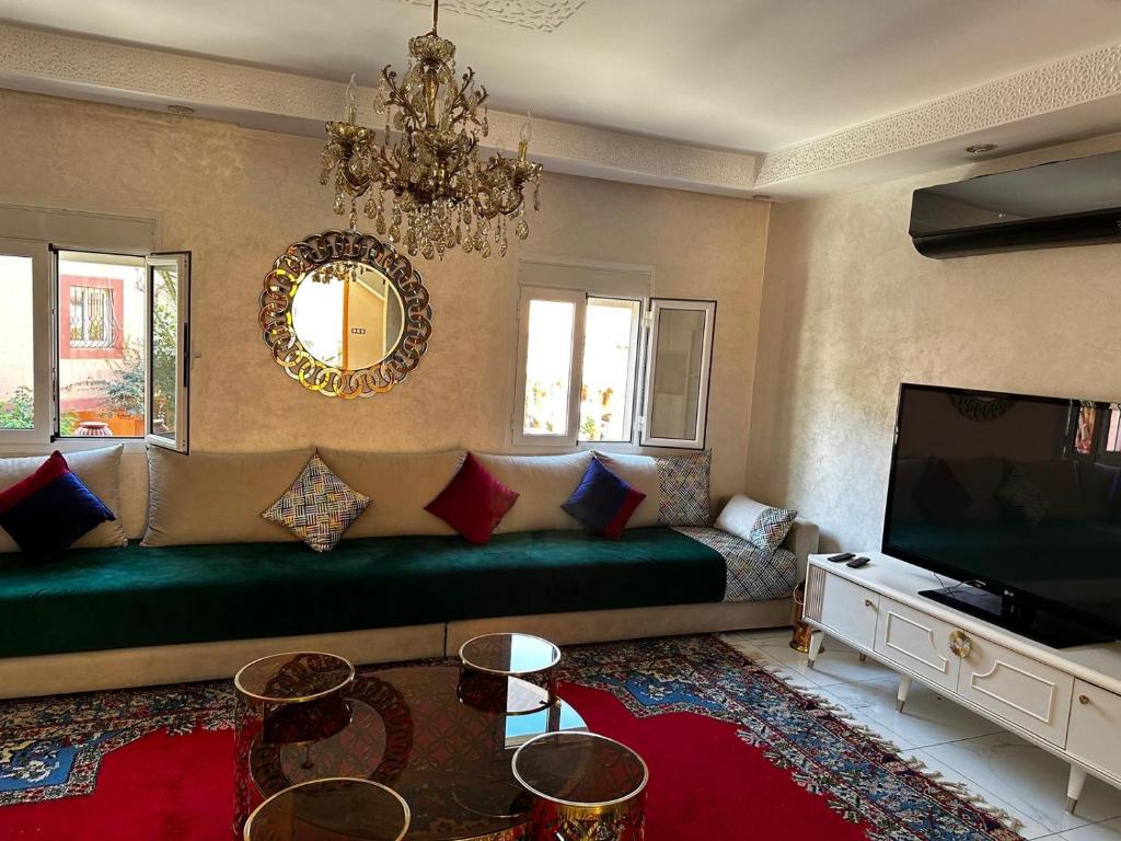 salon z kanapą i telewizorem w obiekcie Riad Jad - Sweet Duplex Appartement w Marakeszu