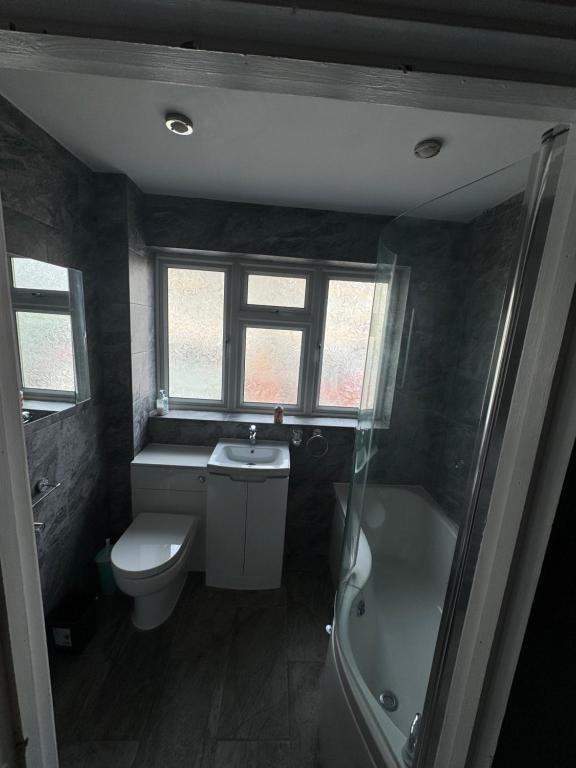 a bathroom with a toilet and a tub and a sink at Urban Oasis in Abbey Wood