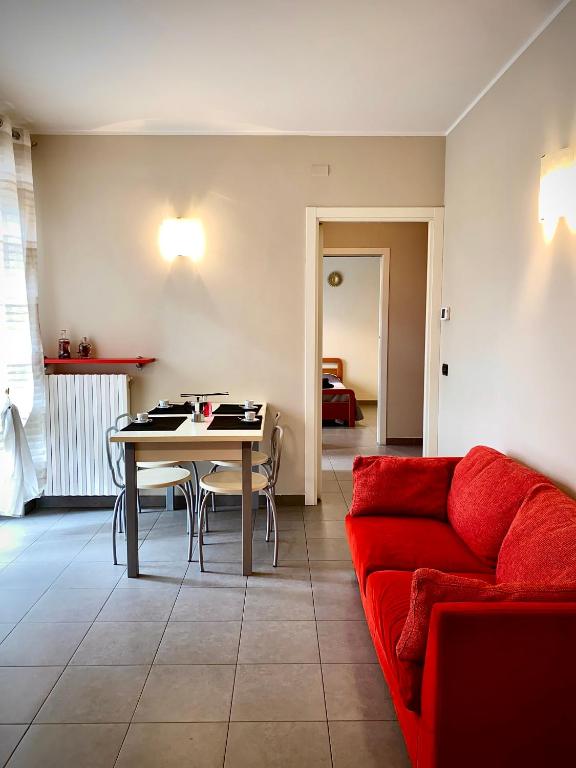 sala de estar con sofá rojo y mesa en Casa Langhetto, en Grinzane Cavour