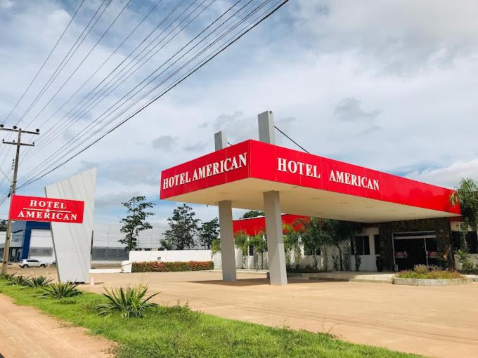 a red hotel american sign in front of a gas station at Hotel American in Ariquemes