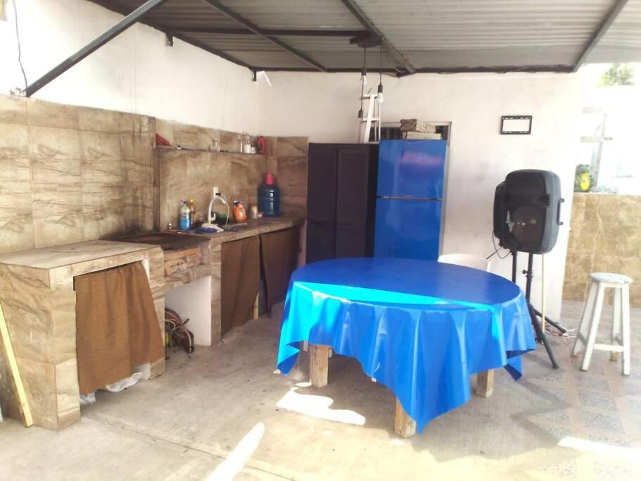 una cocina con una mesa azul en un garaje en Casa con alberca privado cómoda, en Tampico