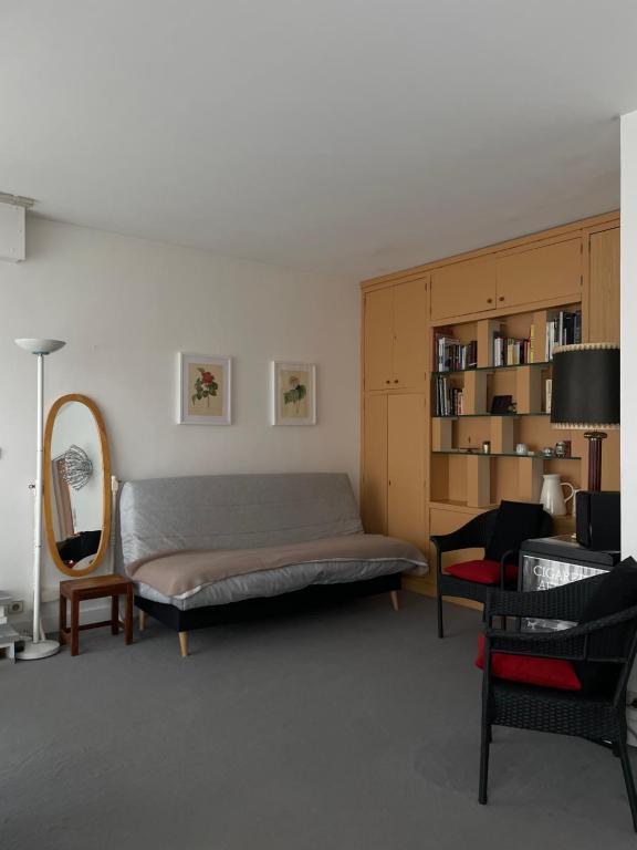 een slaapkamer met een bed, een stoel en een spiegel bij Big apartment with terrace & central location in Parijs