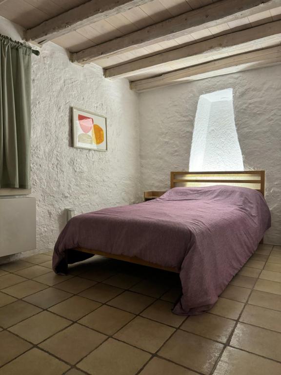 - une chambre avec un lit et une couverture violette dans l'établissement Unique Room in Plaka, à Athènes