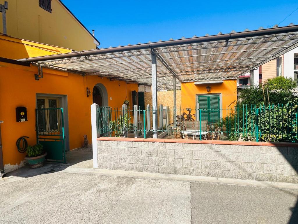 une maison orange avec une pergola sur son côté dans l'établissement Carlitos MAISON, à Pise