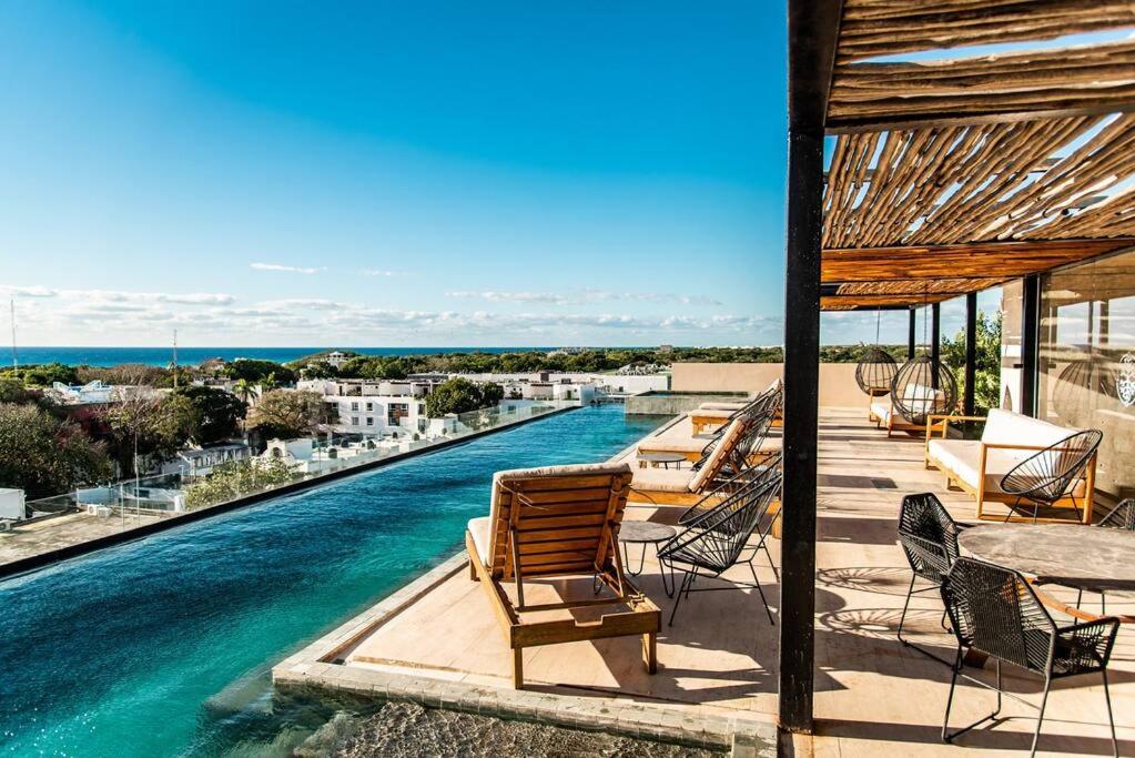 a swimming pool with chairs and a table and water at Studio 2 blks 5th beach shops ac in Playa del Carmen