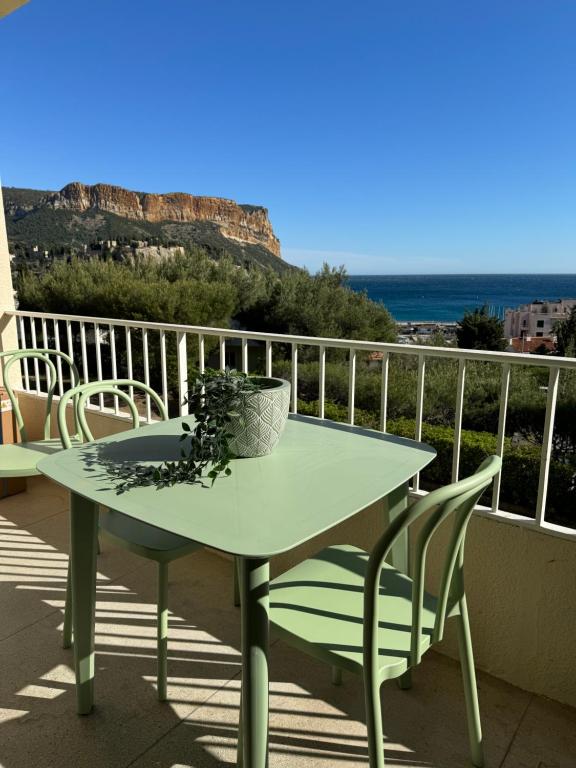 una mesa en un balcón con vistas al océano en Le balcon de la Rade, en Cassis