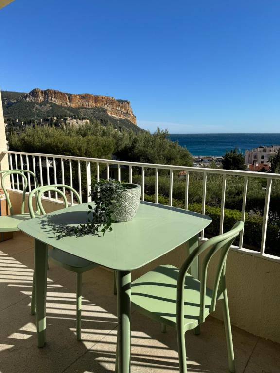 a table on a balcony with a view of the ocean at Le balcon de la Rade in Cassis