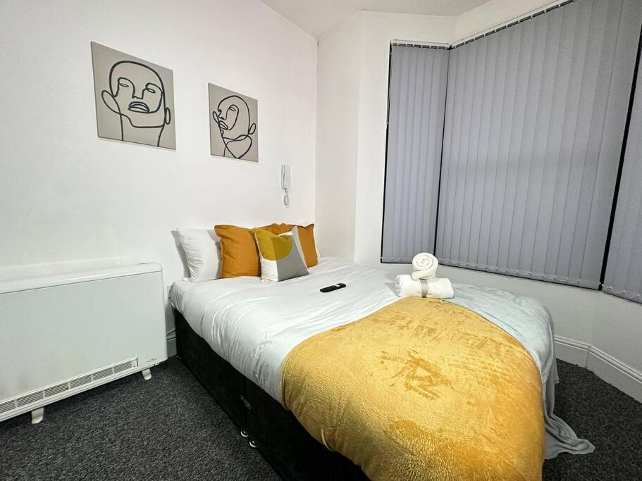 um quarto com uma cama com um cobertor amarelo em Chic Studio Retreat in Kidderminster em Kidderminster
