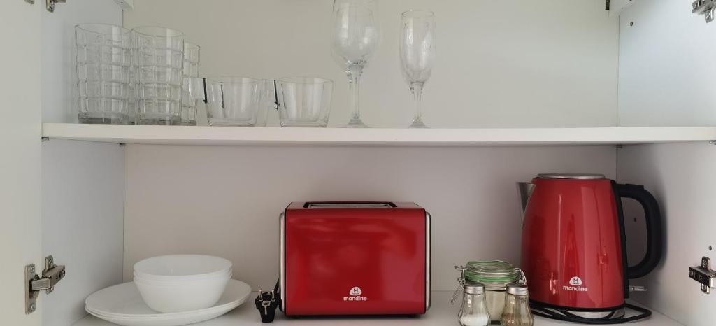 a kitchen counter with a red appliance on a shelf at Urban Sunset Apartment in Sibiu