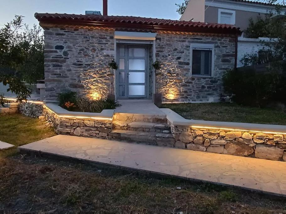 a pathway leading to a stone house with lights at Cozy stone cottage in Myli in Mýloi