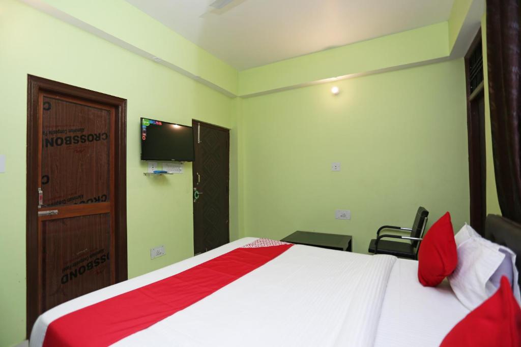 Flagship Near Anisabad Golambar في باتنا: غرفة نوم بسرير وتلفزيون على الحائط