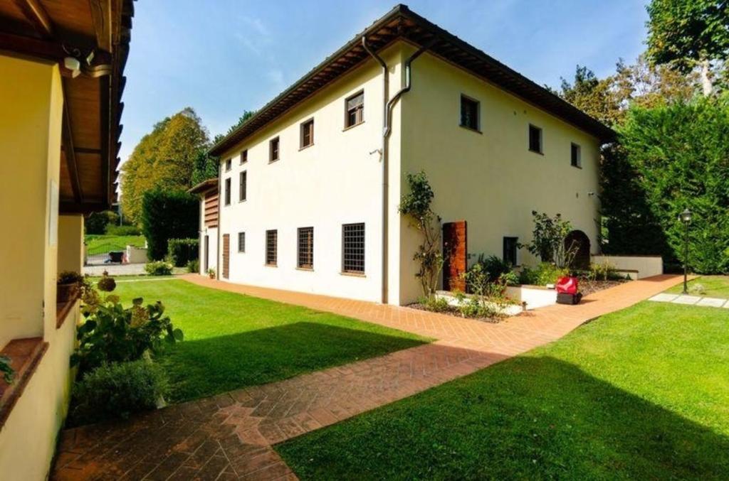 Monsagrati的住宿－Ferienwohnung für 4 Personen ca 50 qm in Monsagrati, Toskana Provinz Lucca，一座带绿色庭院的大型白色房屋