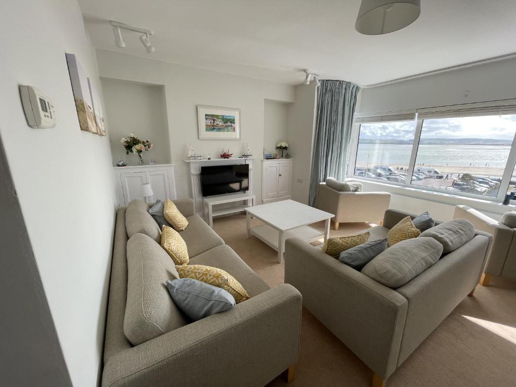 a living room with two couches and a table at Lovely seafront 2 bedroom Apartment 4 in Aberdyfi
