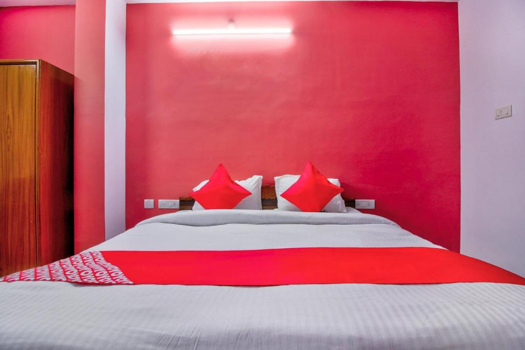 - une chambre rouge avec un lit aux murs rouges dans l'établissement OYO Atithi Bhawan, à Jamshedpur