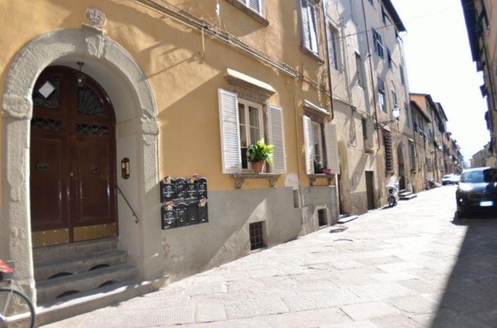 an alley with a building with a door and a car at Ferienwohnung für 4 Personen ca 50 qm in Lucca, Toskana Provinz Lucca in Lucca