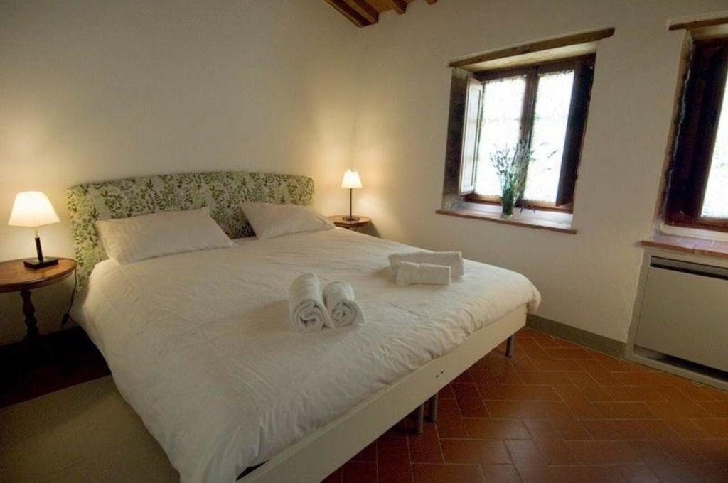 um quarto com uma cama com dois sapatos em Apartment für Paare mit Veranda und Blick auf den Garten em San Donato in Poggio