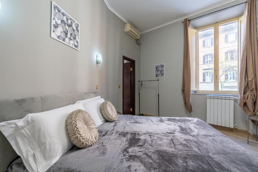 una camera da letto con un grande letto con cuscini sopra di ESQUILINO HARMONY GUESTHOUSE - close to COLOSSEUM a Roma