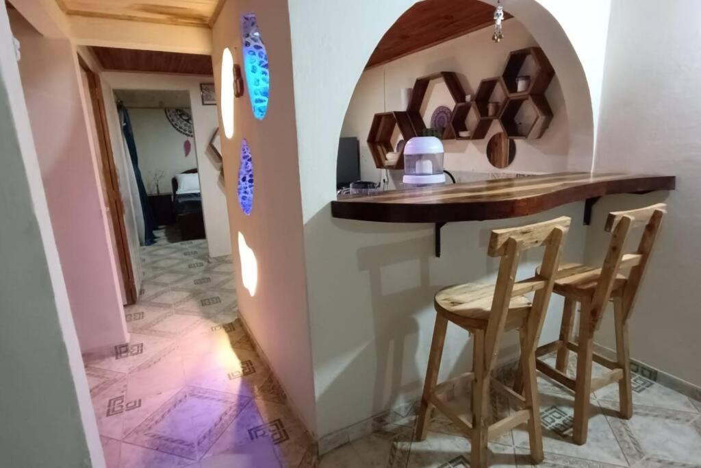 cocina con encimera y taburetes en una habitación en Casa Rio de Cristal, en Pijao