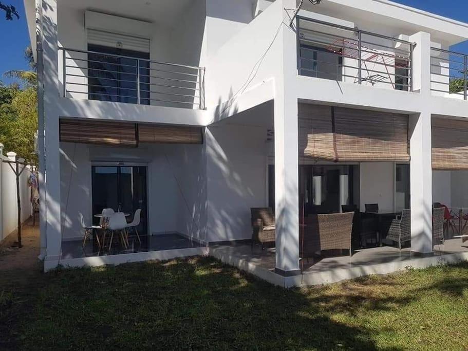 a white house with a table and chairs in a yard at Villa Vielet Lalovina in Mahajanga