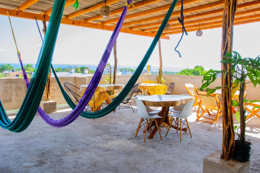 d'une terrasse avec des hamacs, une table et des chaises. dans l'établissement Posada Girasol, à Puerto Escondido