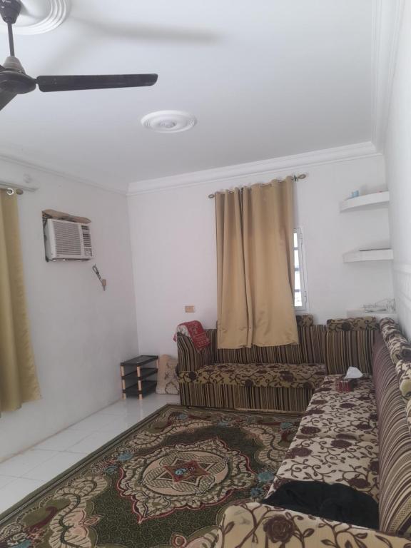 a living room with a couch and a rug at شقة في جعلان ( بيت عربي) اجار يومي واسبوعي in Şūr Maşīrah