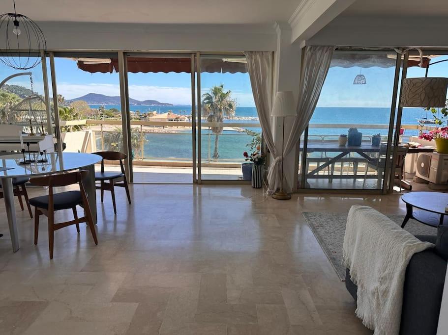 a living room with a table and a view of the ocean at Appartement panoramique sur mer in Toulon