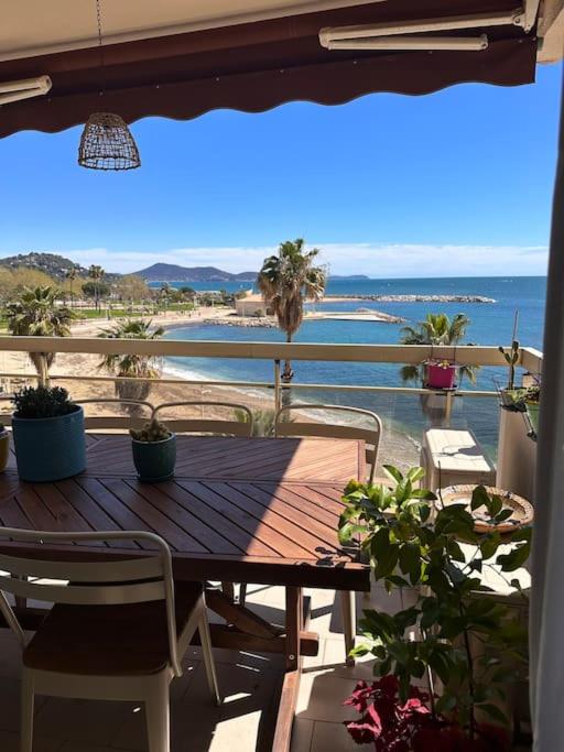 a wooden table on a balcony with a view of the ocean at Appartement panoramique sur mer in Toulon