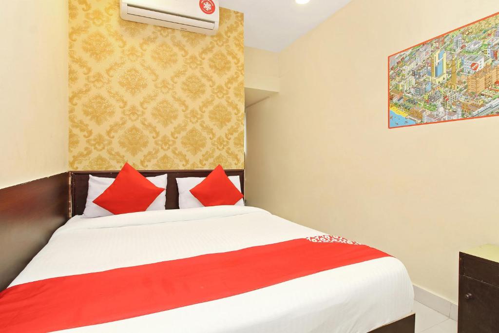 1 dormitorio con 1 cama con almohadas rojas en OYO Vasundhara Guest House Near Tankbund, en Secunderābād