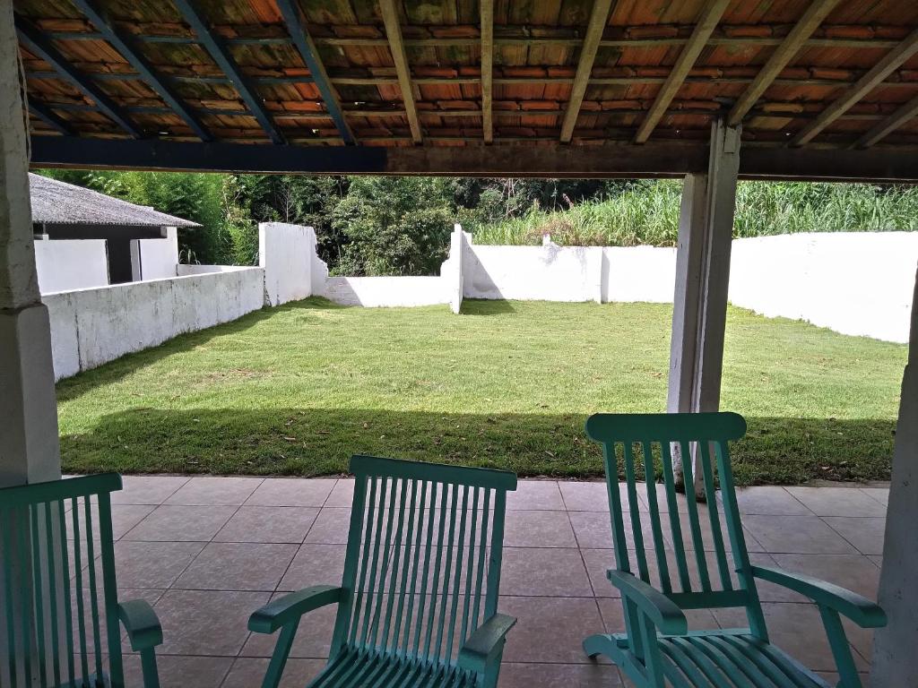 Duas cadeiras verdes sentadas num pátio com um quintal em Joanopolis Inn - Mantiqueira 1 em Joanópolis