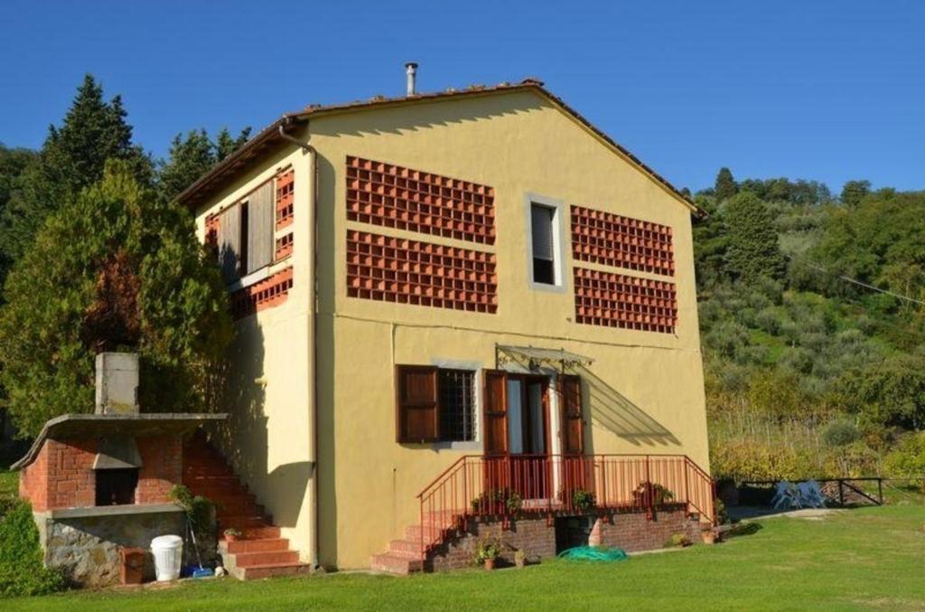 mały żółty dom z gankiem i schodami w obiekcie Ferienhaus mit Privatpool für 5 Personen ca 65 qm in Petrognano, Toskana Provinz Lucca w mieście San Gennaro