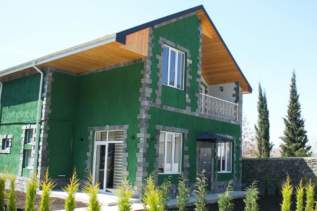 a green house with a gambrel roof at İnci in Sheki