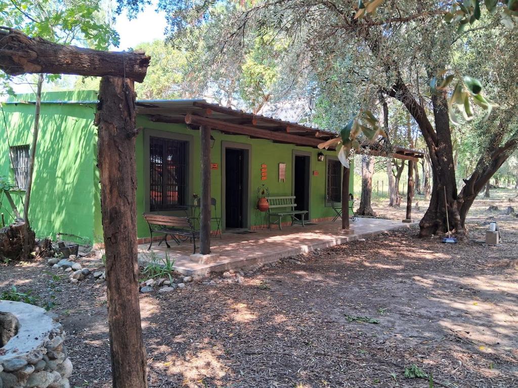 una casa verde con un banco delante en Abuela Faustina in 