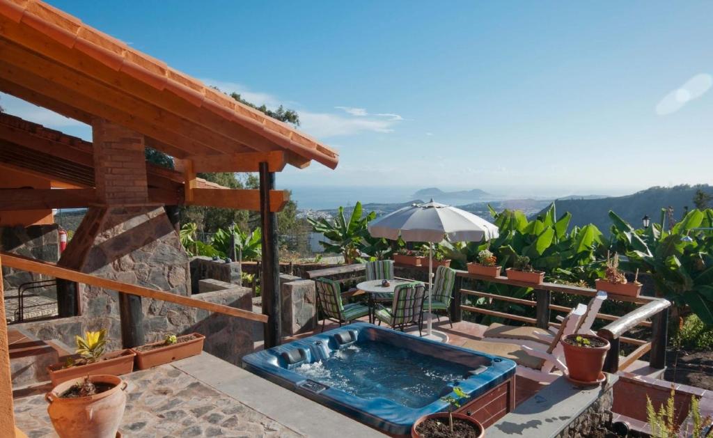 um pátio com uma banheira de hidromassagem e um guarda-sol em Ferienhaus für 5 Personen ca 58 qm in Arucas, Gran Canaria Nordküste Gran Canaria em Arucas