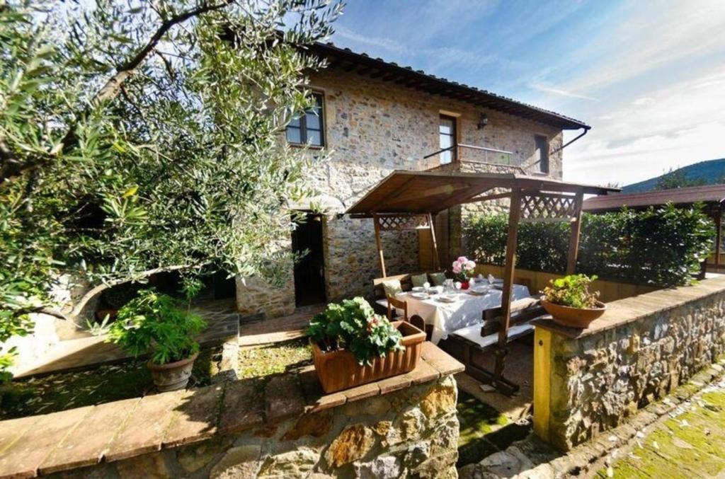 een huis met een tafel ervoor bij Ferienhaus für 8 Personen ca 100 qm in Buti, Toskana Provinz Lucca in Buti