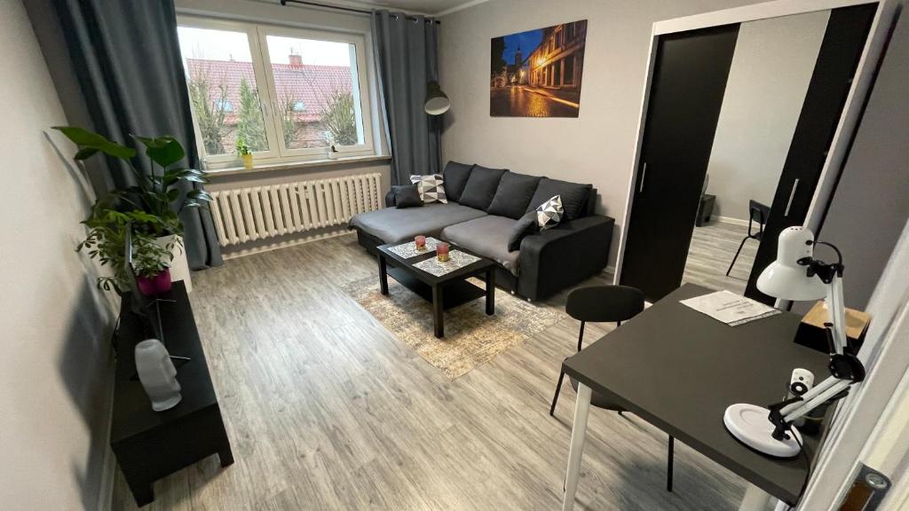 ein Wohnzimmer mit einem Sofa und einem Tisch in der Unterkunft Apartament Reszel in Reszel