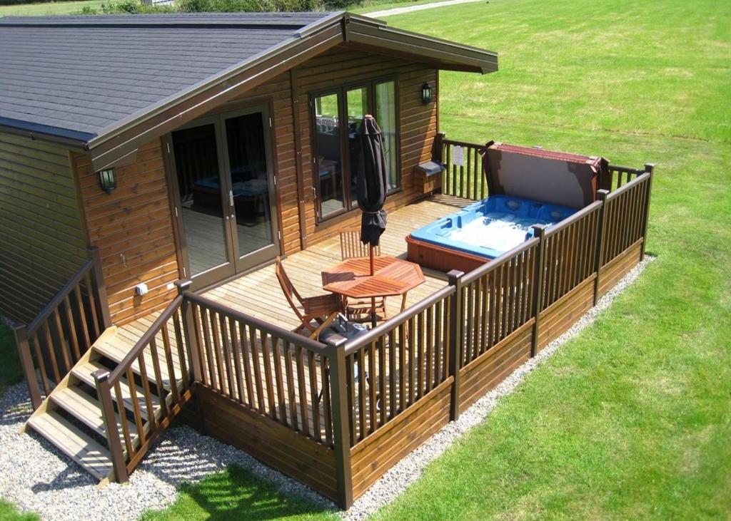 a large deck with a hot tub on a house at Wighill Manor Lodges in Tadcaster