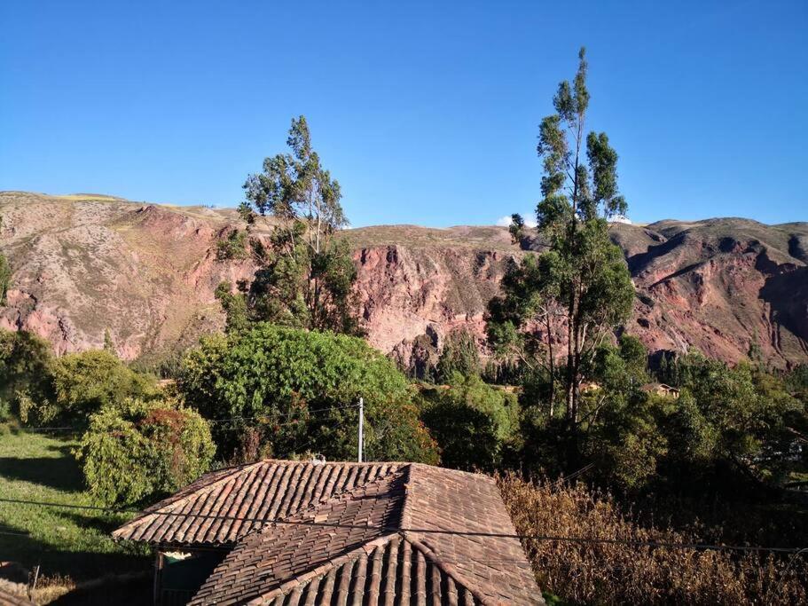 a roof of a building with mountains in the background at Casa de las Flores, Valle Sagrado Cusco in Urubamba