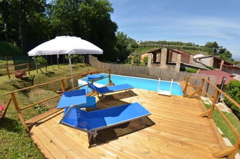 um deque com cadeiras, um guarda-sol e uma piscina em Ferienhaus mit Privatpool für 2 Personen ca 40 qm in Capannori, Toskana Provinz Lucca em Capannori