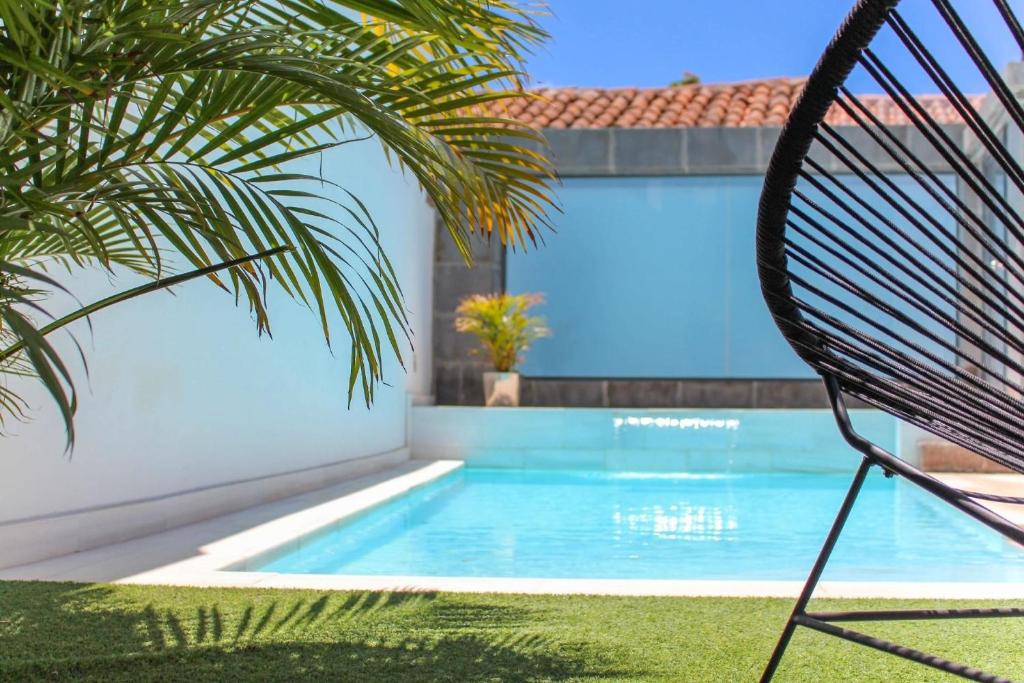 una sedia accanto alla piscina accanto a una casa di Ferienhaus mit Privatpool für 2 Personen ca 150 qm in Santa Lucía de Tirajana, Gran Canaria Binnenland Gran Canaria a Santa Lucía