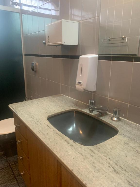 a bathroom sink with a soap dispenser on a counter at Dulc in Ribeirão Preto