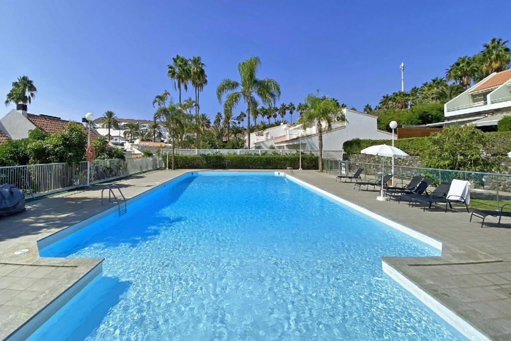 a swimming pool with blue water in a yard at Ferienhaus für 6 Personen ca 130 qm in Pasito Blanco, Gran Canaria Südküste Gran Canaria - b63552 in Pasito Blanco