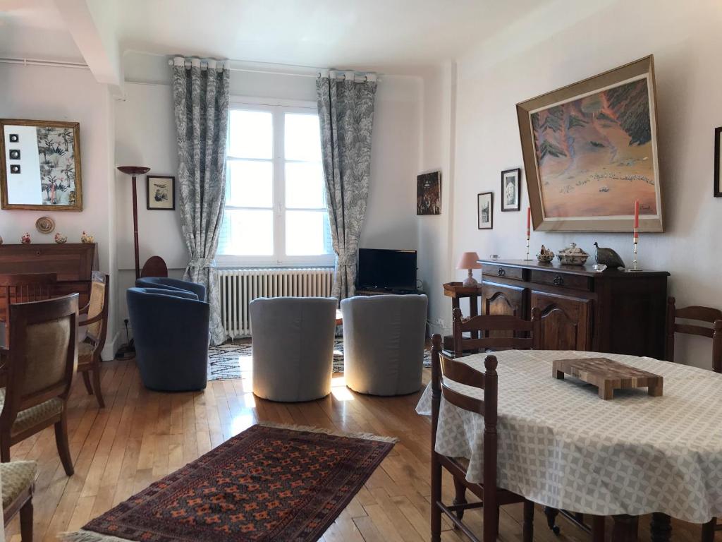 een woonkamer met een tafel en stoelen bij LE DOUMER - Garage - Gare - Hyper Centre in Vichy