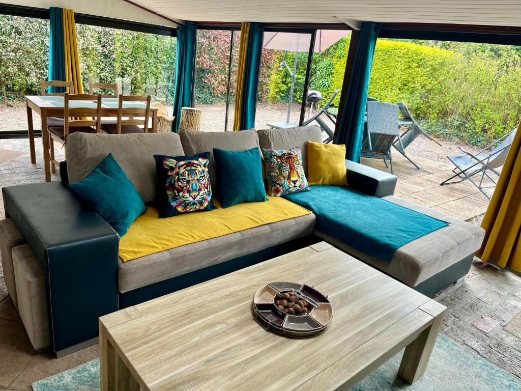 sala de estar con sofá y mesa en La Maisonnette d'Hermival à 2 min de Lisieux - Jardin - Pkg - Wifi en Hermival-les-Vaux