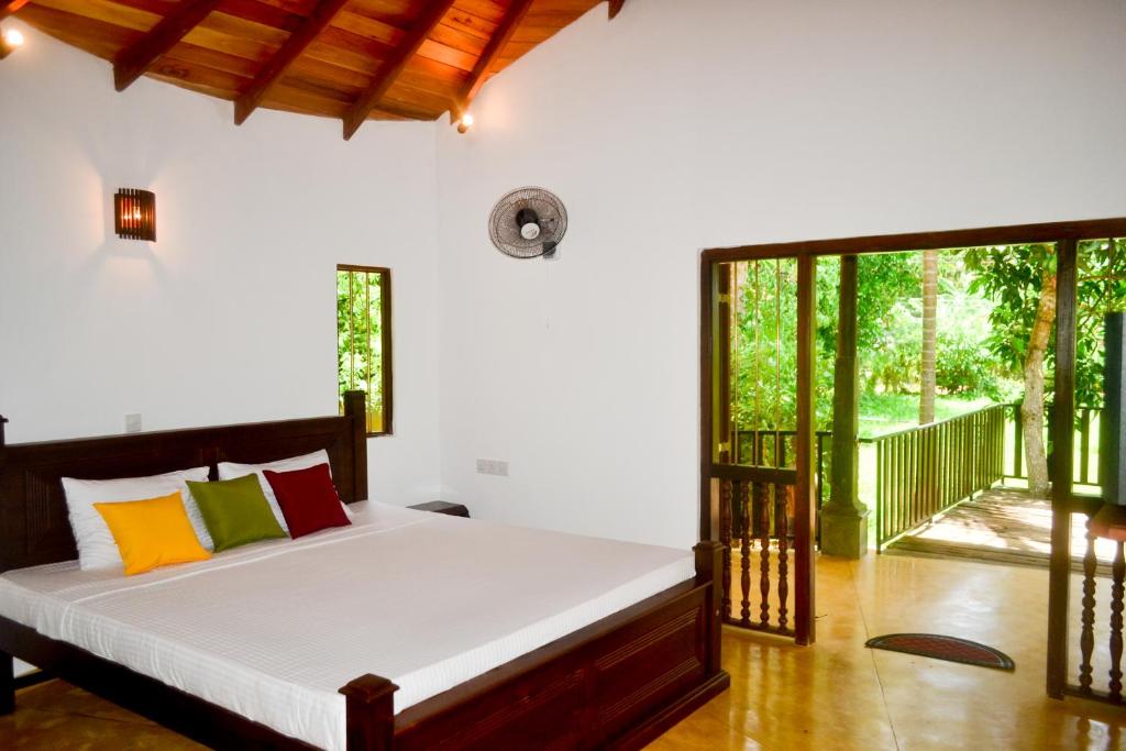 Un dormitorio con una cama y una ventana grande. en Guruwaththa Eco Lodge, en Hikkaduwa