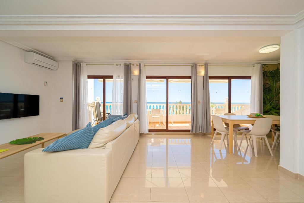 a living room with a white couch and a table at Front Line Apartment Jakarta 2 in El Campello